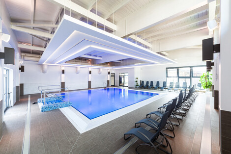 blauer Pool mit Liegestühlen