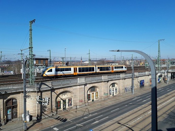 Zug fährt auf Hochschienen durch die Stadt
