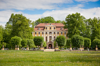 gelbes Barockschloss in grünem Park