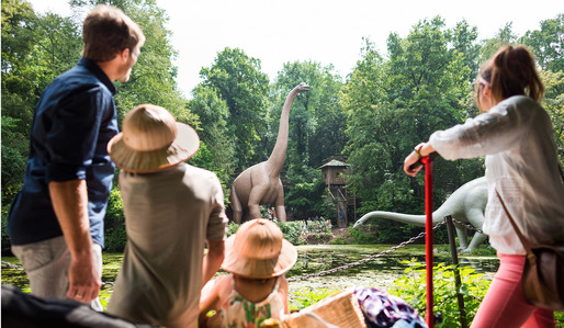 Familie mit Kindern blickt auf großen Dinosaurier
